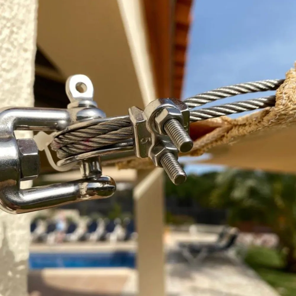 Close-up of a stainless steel turnbuckle and cable on a shade sail